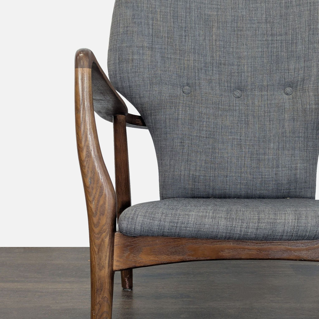 Elegant grey lounge chair featuring a classic wood frame and soft upholstery for comfortable, modern seating.