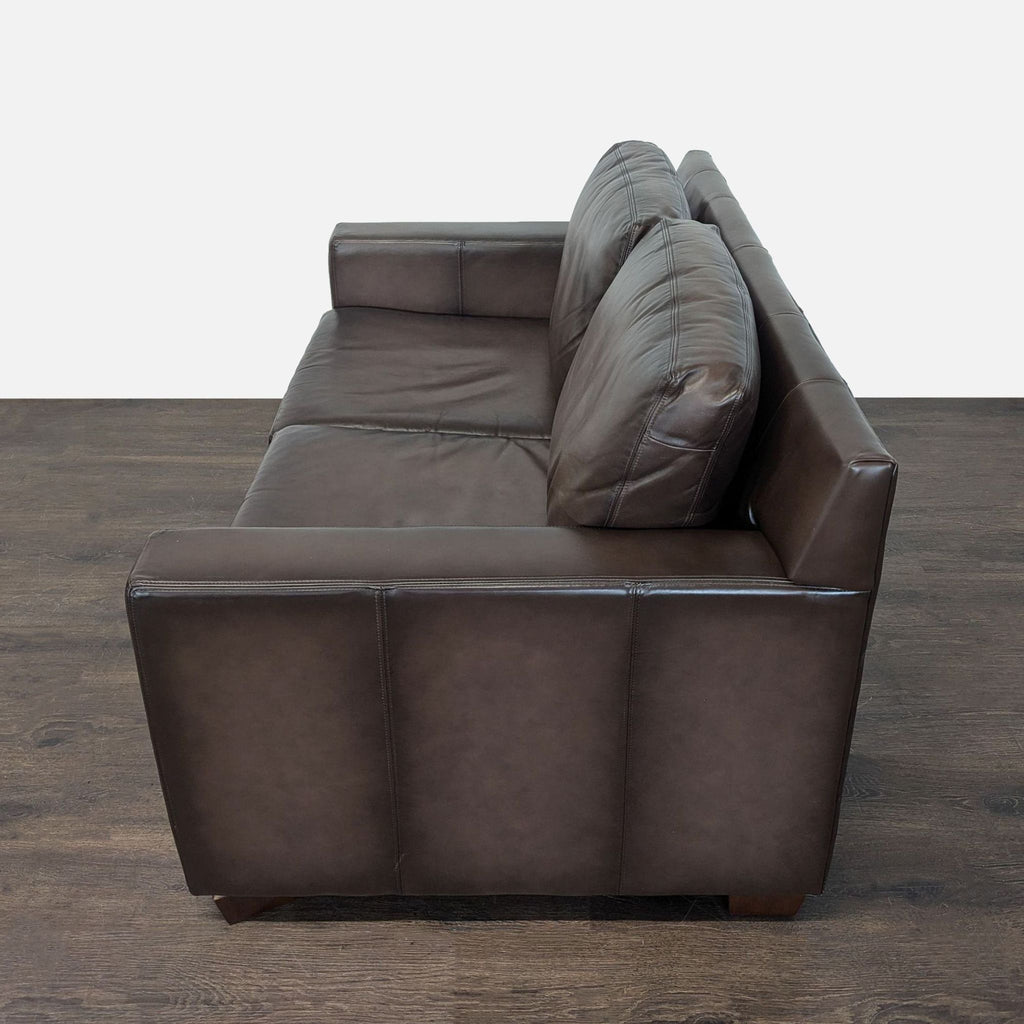 Plush brown leather loveseat by Pottery Barn, featuring a sleek, modern look and sturdy construction.