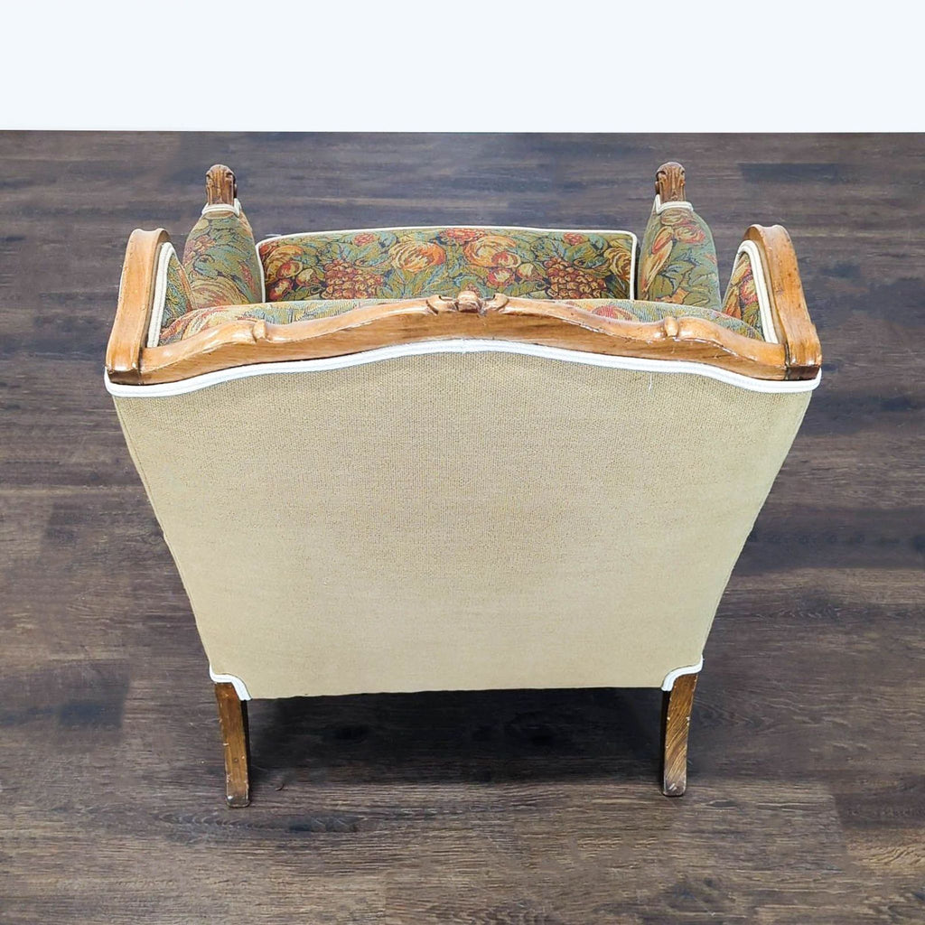 2. Back view of an elegant lounge chair showing cream fabric, wooden trim, and colorful floral upholstery inside.