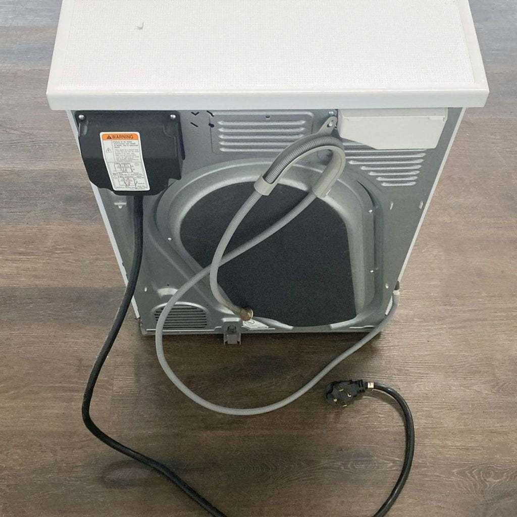 3. Rear view of an LG washer/dryer showing cords, hoses, and power connections on a wood floor.