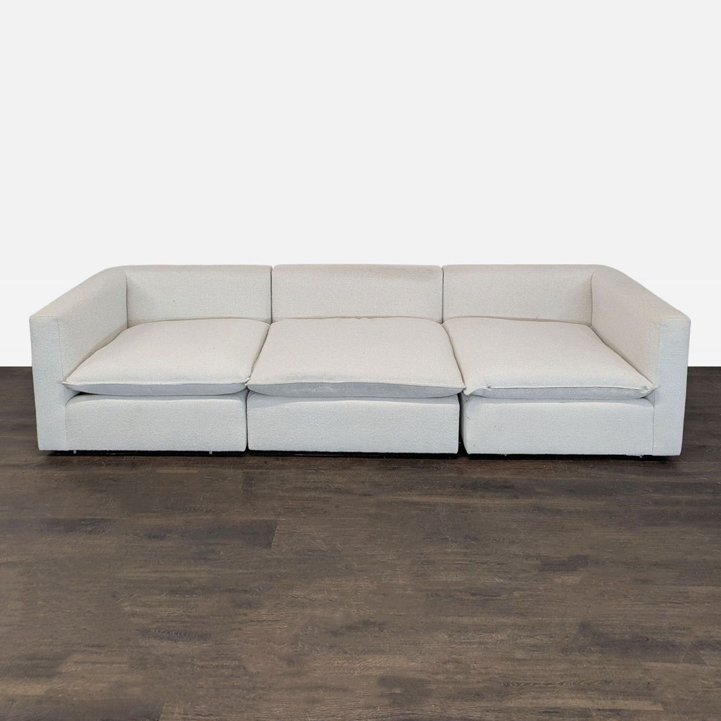 Crate & Barrel 3-seat sofa in light beige fabric with wide arms and plush cushions, seating three comfortably.