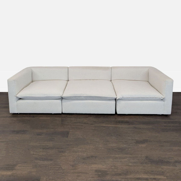 Crate & Barrel 3-seat sofa in light beige fabric with wide arms and plush cushions, seating three comfortably.