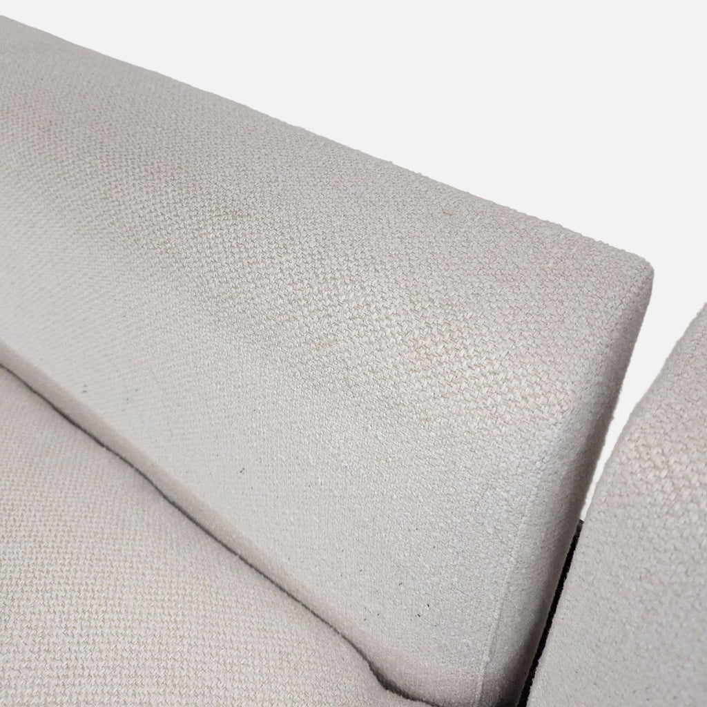 Modern Crate & Barrel sofa with soft, textured beige upholstery and broad arms, ideal for living spaces.