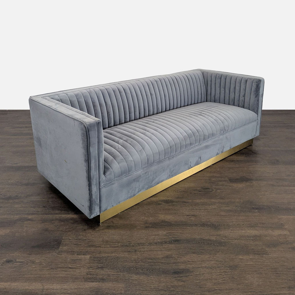 Soft gray velvet Modway sofa, features vertical channel tufting, sturdy gold base, and seats three comfortably.