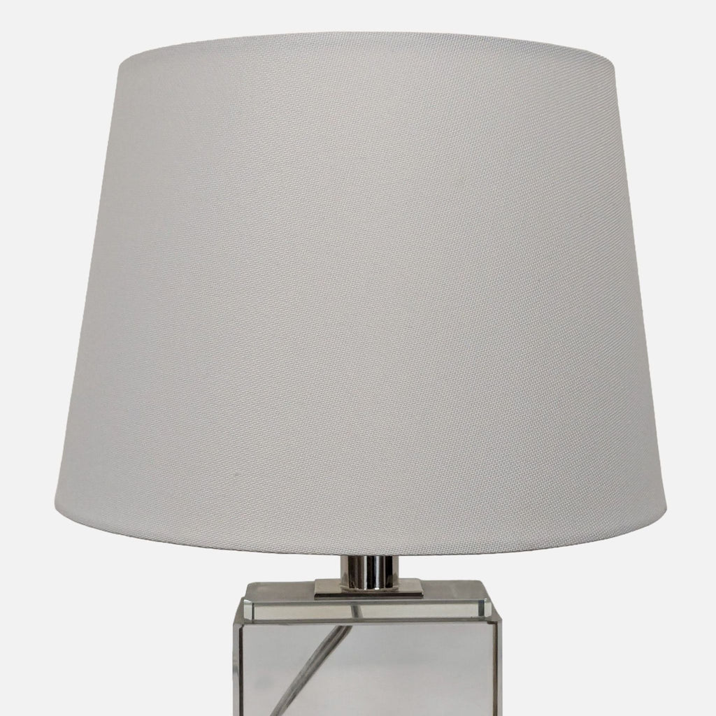 Sleek table lamp from the Lighting category, featuring a transparent base and simple fabric shade.