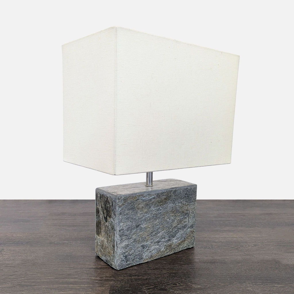 Modern table lamp with a solid stone base and a white rectangular shade, ideal for contemporary spaces.  