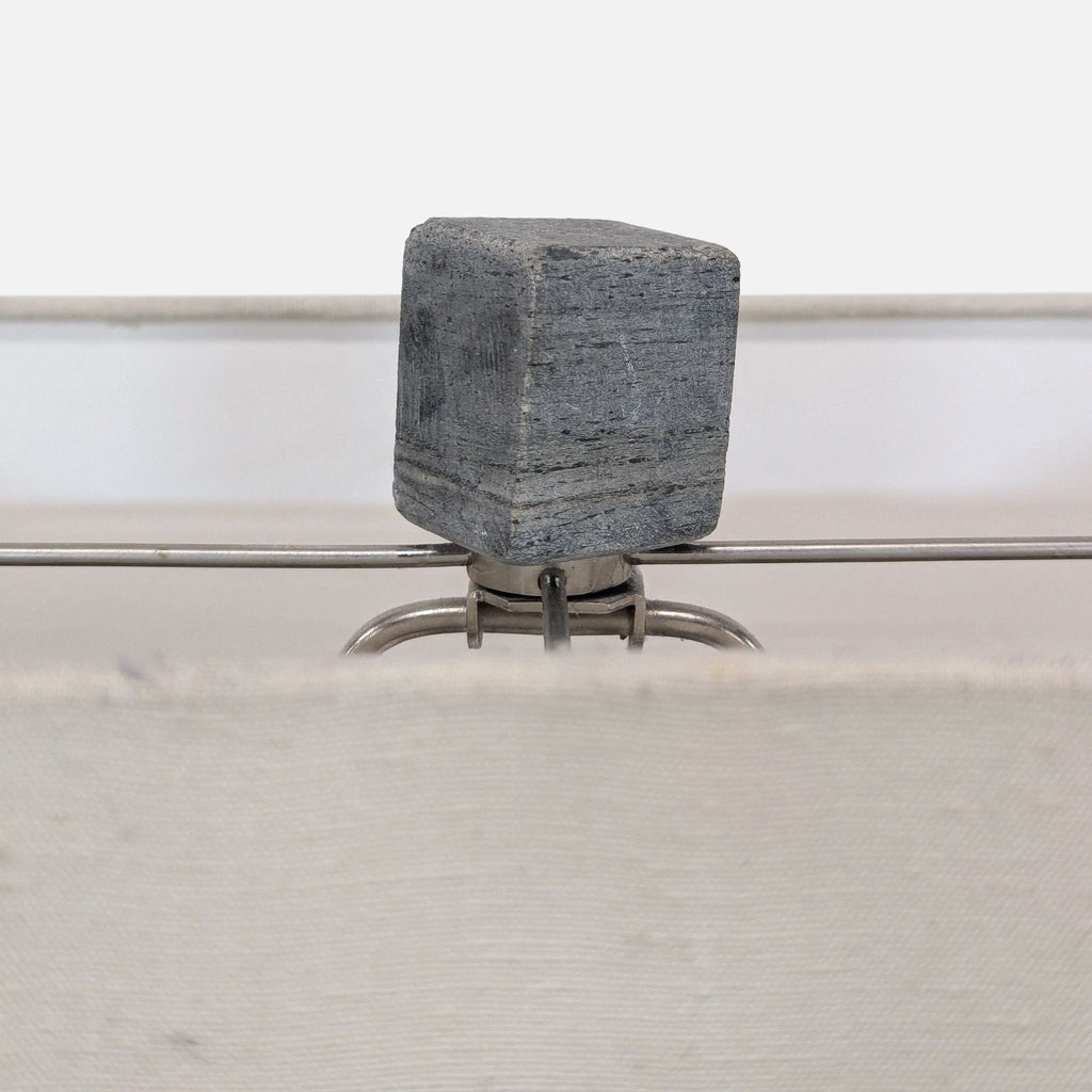 Sleek lighting piece with clean lines, combining a stone base and white fabric shade for a refined touch.