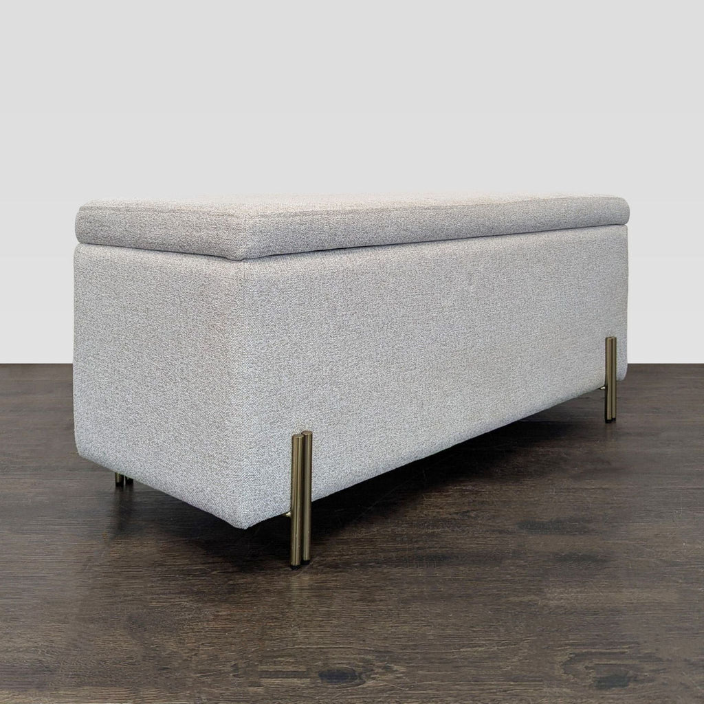 Plated iron-legged bench in antique brass finish, featuring hidden storage and adjustable feet.