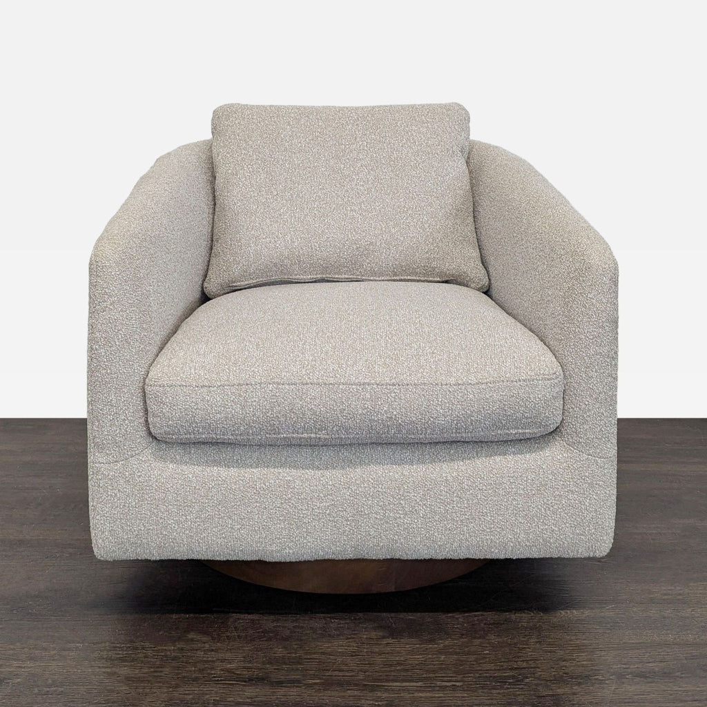 West Elm lounge chair in beige fabric with a swivel base, offering comfort and modern style for any lounge.
