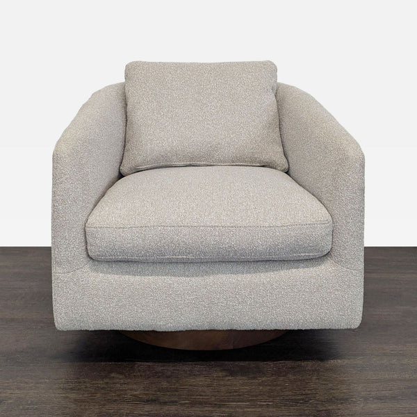 West Elm lounge chair in beige fabric with a swivel base, offering comfort and modern style for any lounge.