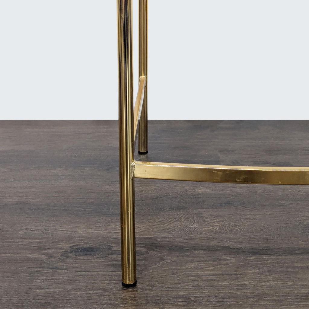 Contemporary CB2 stool featuring a transparent acrylic seat and sleek gold legs, ideal for modern interiors.  