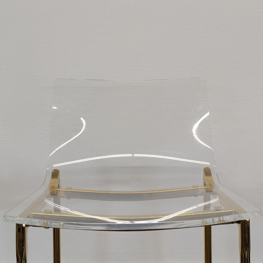 Gold-legged clear acrylic stool by CB2, versatile for seating or decor in the Stools, Ottomans & Benches range.