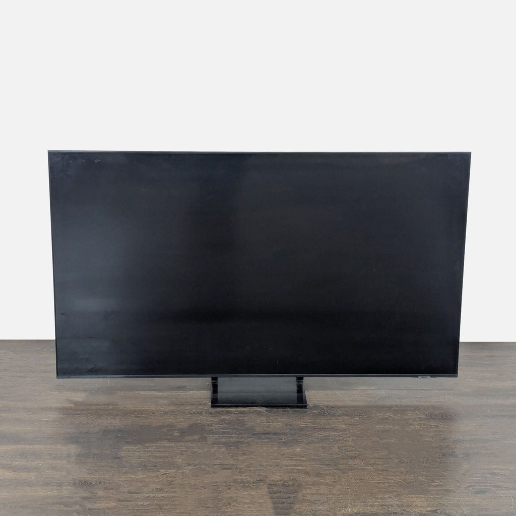 Samsung 65-inch LED Smart TV on stand, screen displaying vibrant image; ideal for home entertainment.