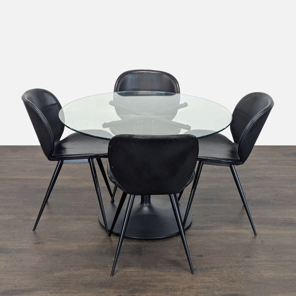 Room and Board dining set with round glass table and four black chairs, stylish modern design.