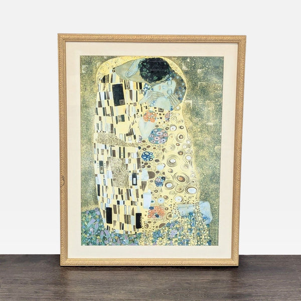 Framed print of Gustav Klimt’s "The Kiss" with vivid colors in a gold-patterned frame, ready to hang.