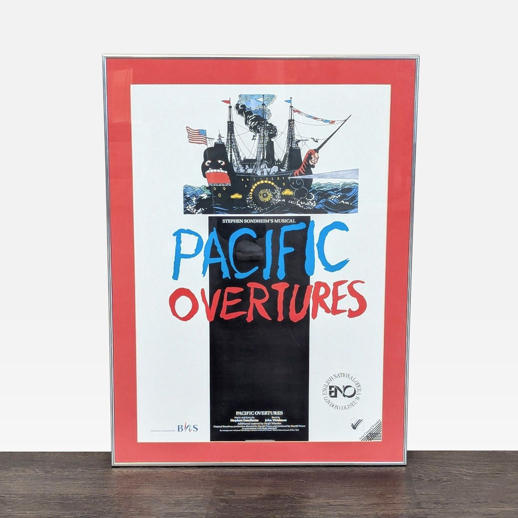 Framed print of "Pacific Overtures" with bright ship artwork and bold title, matted in red for display.  