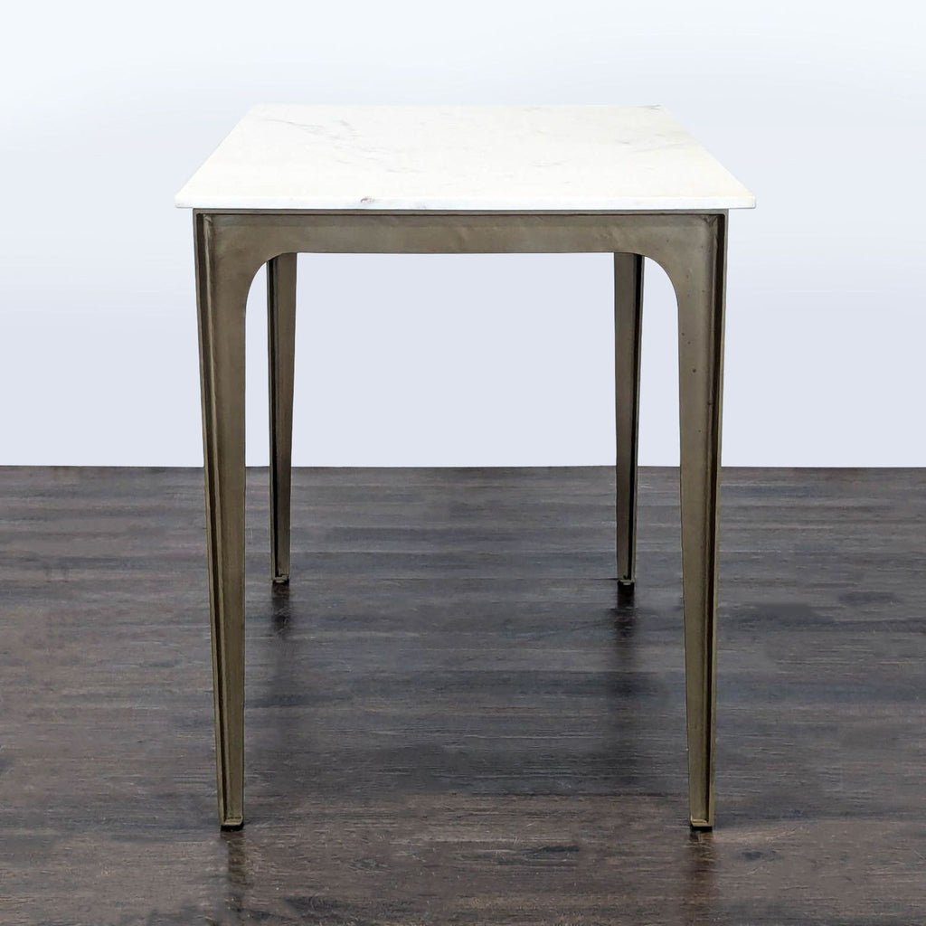 Contemporary marble dining table with smooth white-grey veined top and tapered bent metal legs, fits six people.