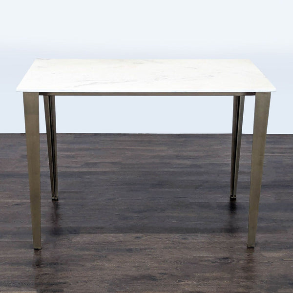 Industrial-style dining table with white Carrara marble top and antiqued brass-finished iron legs, seats six.