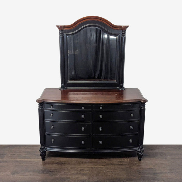 Black dresser with brown top, nine drawers, and matching mirror, ideal for bedroom storage.