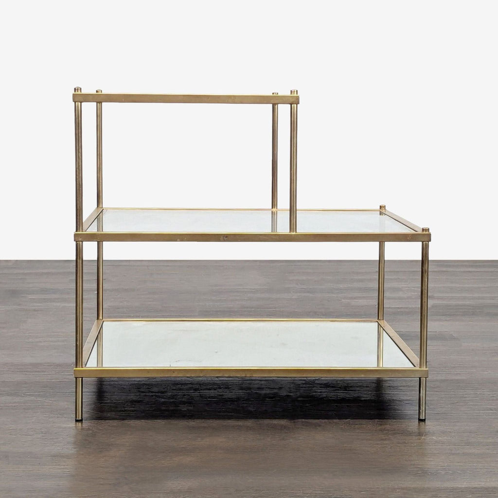 Chic gold-frame end table featuring two transparent glass tiers and a reflective mirrored shelf.