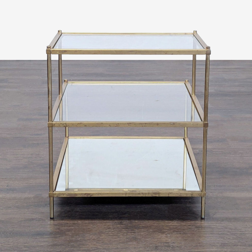 Contemporary end table with gold accents, including double glass surfaces and a single mirrored shelf.