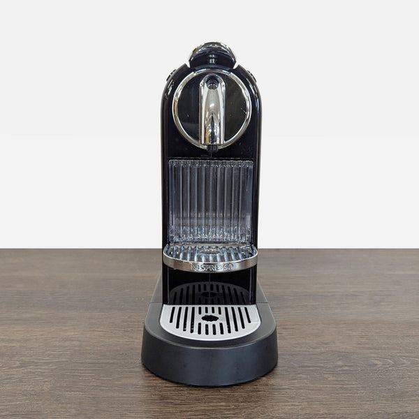 Sleek black Nespresso coffee maker with compact design, ideal for counters, featuring one-touch pod brewing.  