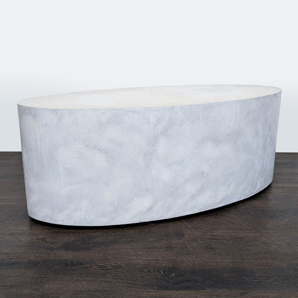 Sculptural oval concrete coffee table in smoke finish with hidden wheels, by Eric Weil Designs.