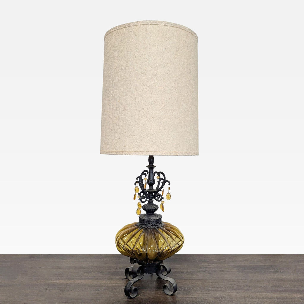 Vintage table lamp with amber glass base, black metal stand, and beige shade, featuring hanging amber droplets.