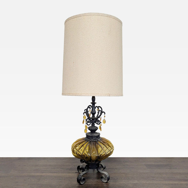 Vintage table lamp with amber glass base, black metal stand, and beige shade, featuring hanging amber droplets.