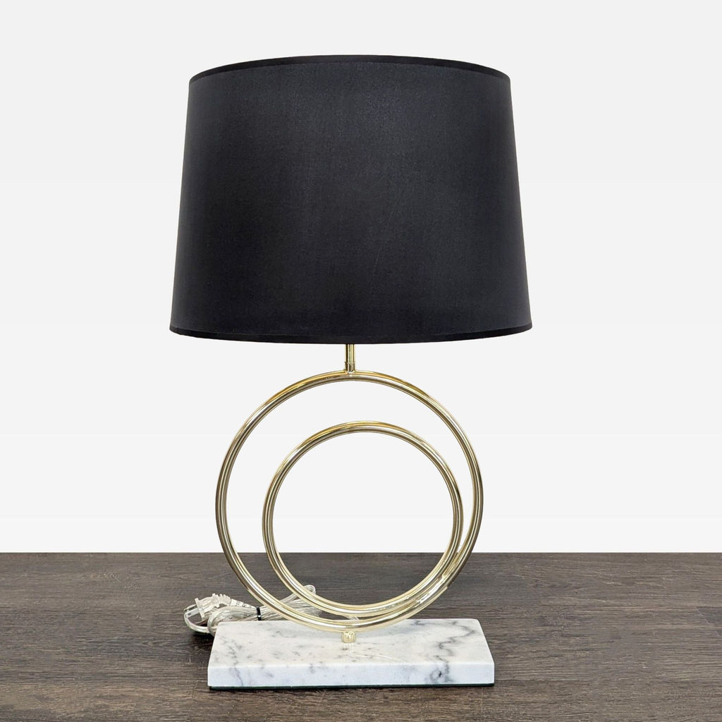 Modern table lamp with a black shade, gold circular accents, and a marble base, ideal for any room.