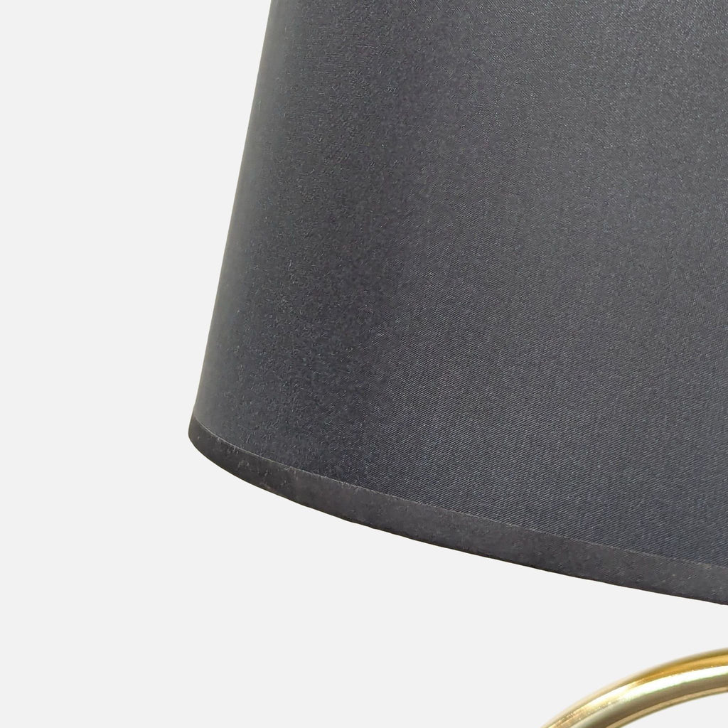 Contemporary lamp featuring a black top, gold metal circles, and sturdy marble base, adding elegance to décor.