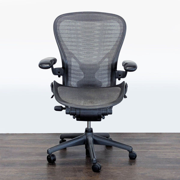 Herman Miller Aeron chair with mesh seat and back, adjustable armrests, and rolling base for ergonomic seating.