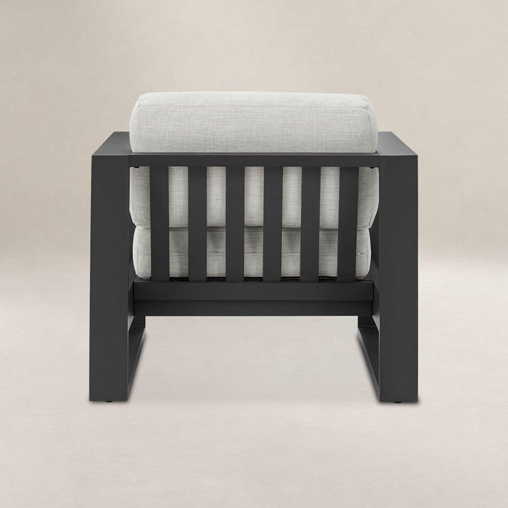 Light grey cushioned chair by Castlery with supportive backrest and wide seat on a black metal base.