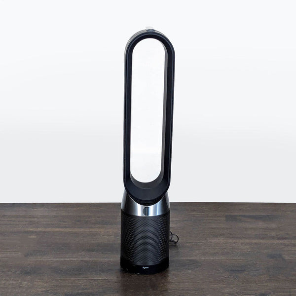1. Dyson bladeless tower fan standing on a floor, designed for cooling large indoor spaces.  