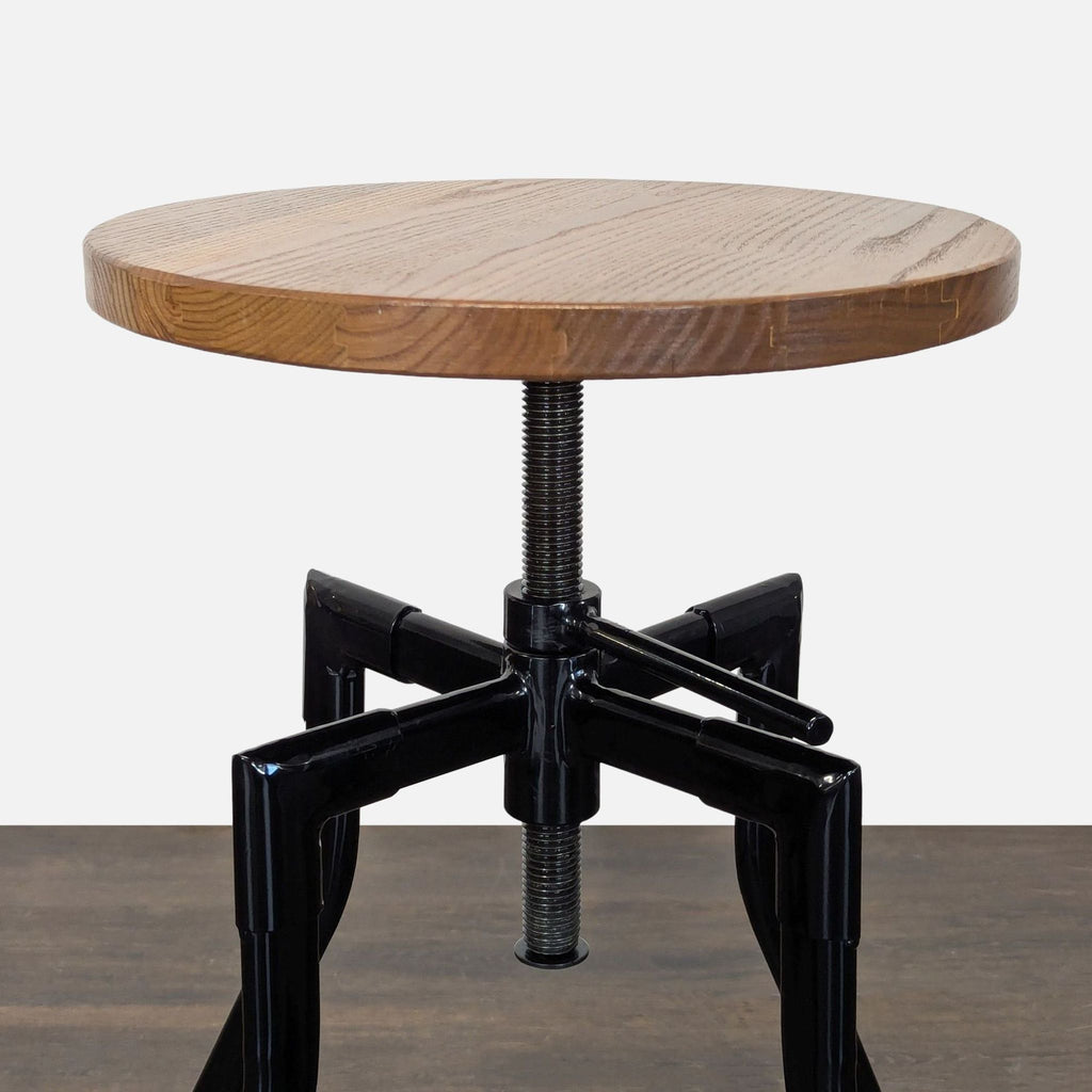 Adjustable-height stool featuring a round wood seat and sturdy black metal legs.