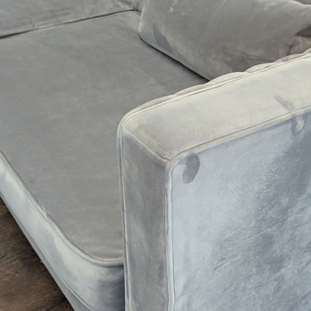 Sleek Alder & Tweed sofa, grey velvet upholstery, vertical tufting, two pillows, and sturdy wooden feet.