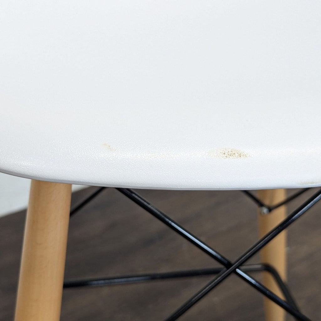 Dining chair with molded plastic seating and natural wood legs, designed for comfort and style.
