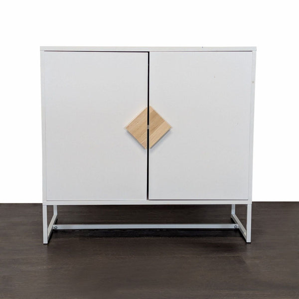 Modern white cabinet with wooden handles and metal base, includes two spacious interior shelves.  