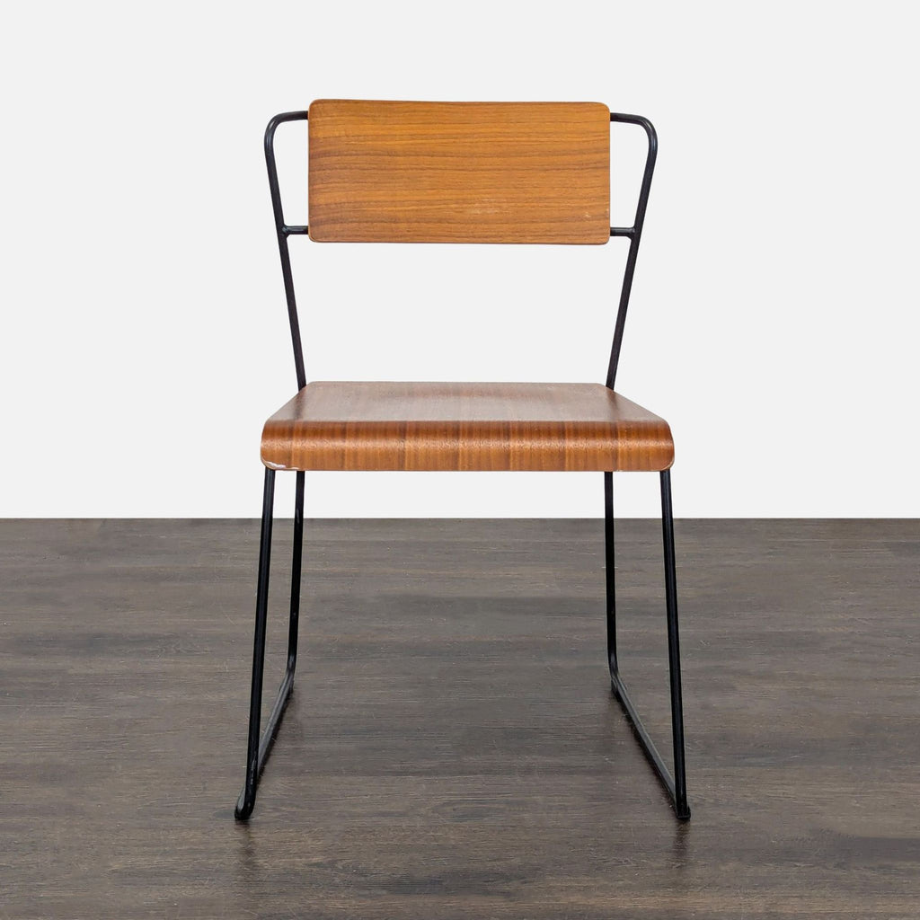 Minimalist dining chair by m.a.d. featuring moulded plywood panels on a continuous steel wire frame.  