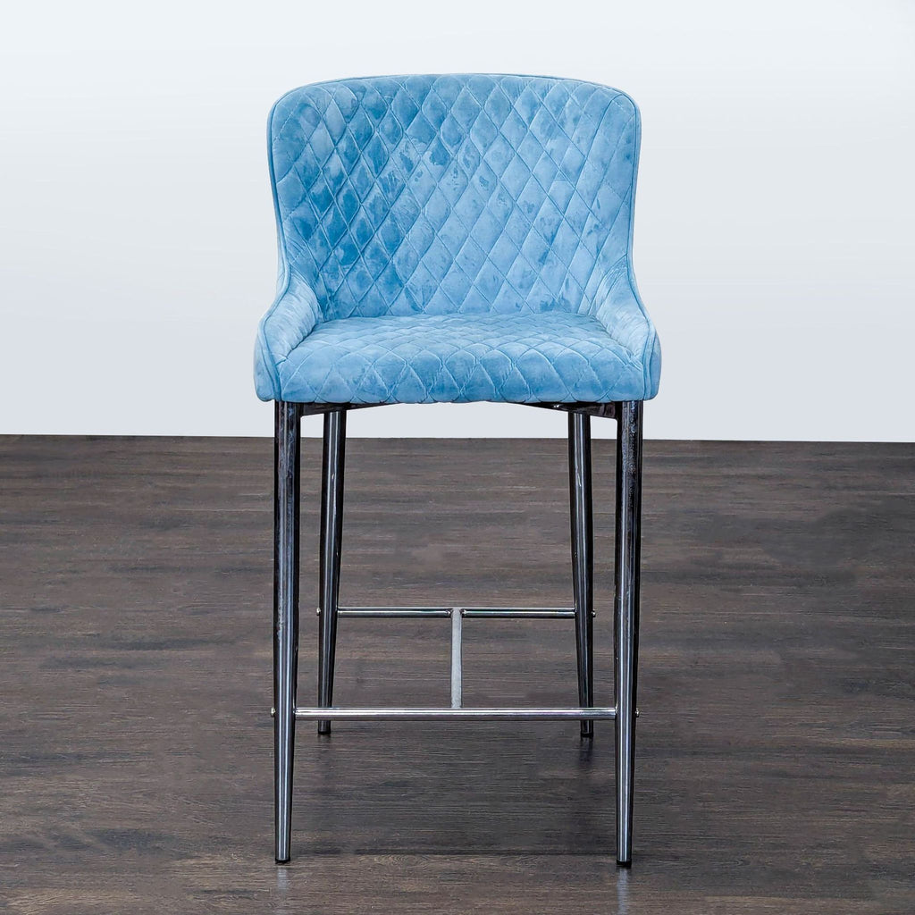 Blue velvet bar stool with quilted pattern and chrome legs, ideal for modern kitchens or dining spaces.