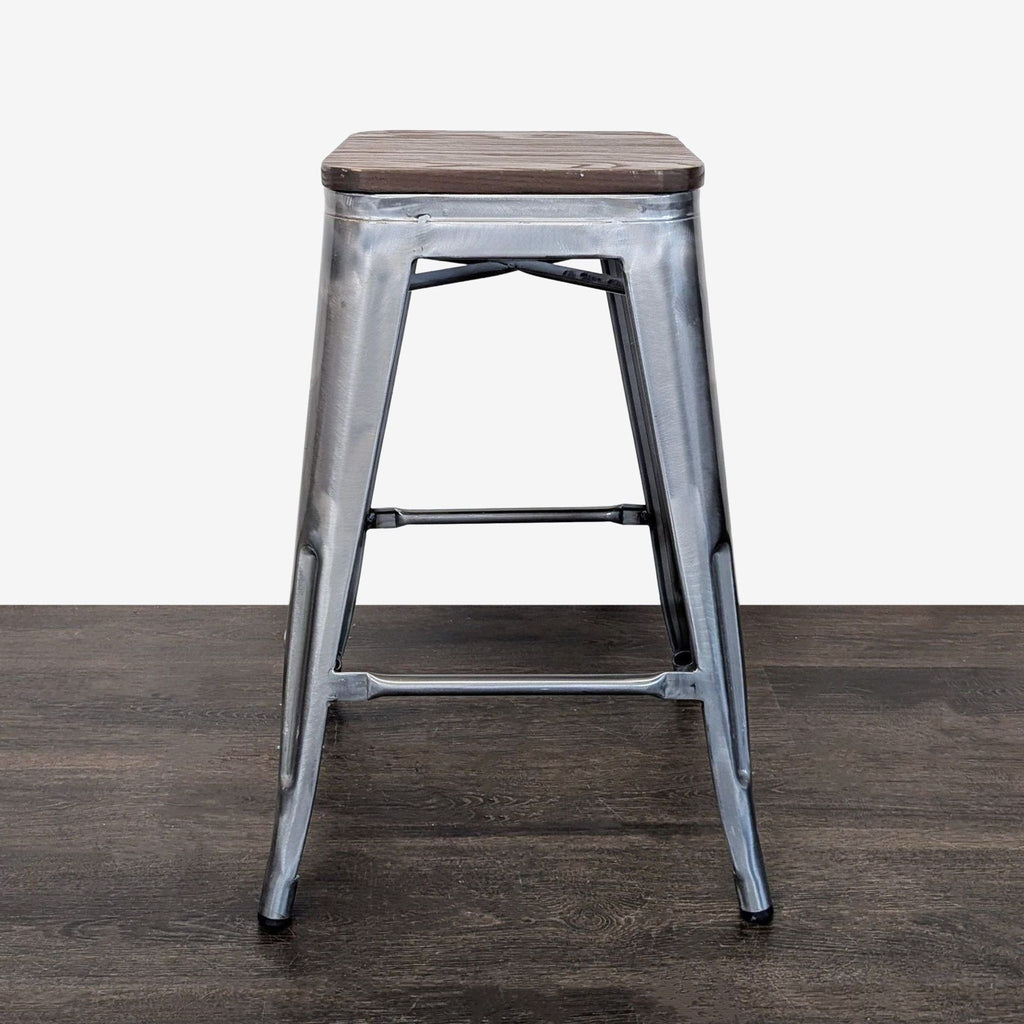 Industrial metal stool with square wooden seat, sturdy frame, and footrest, ideal for kitchens or bars.