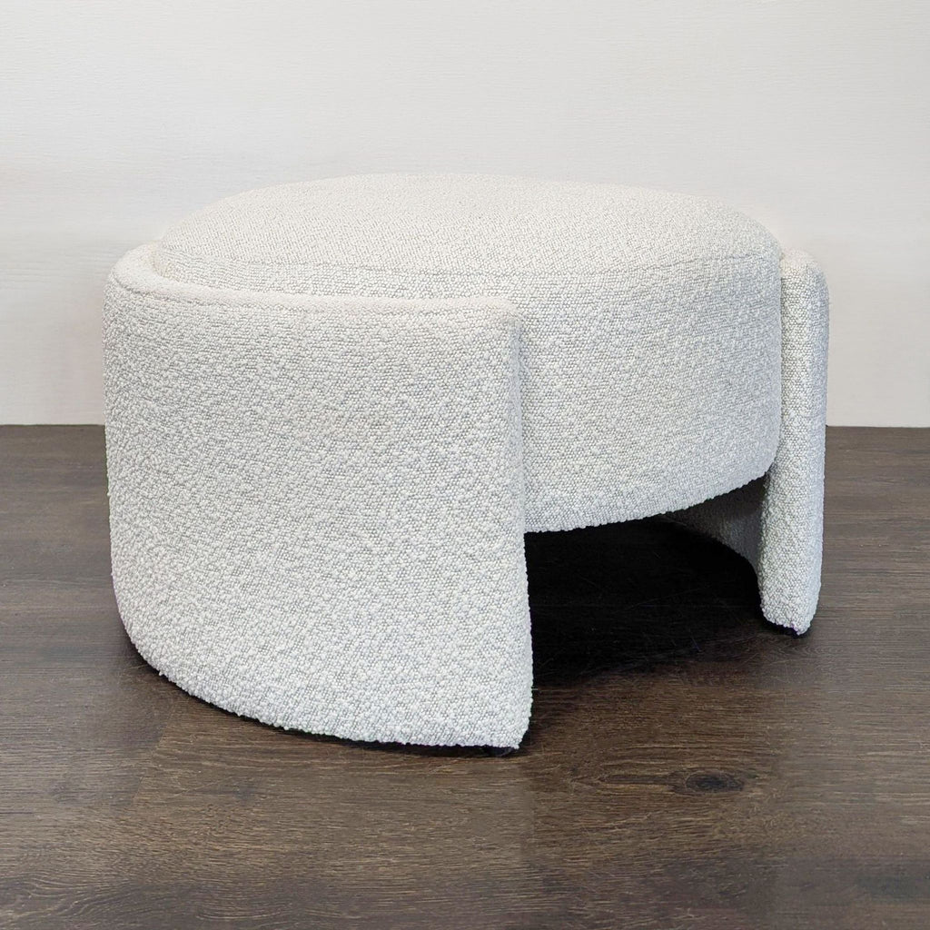 Plush contemporary ottoman in soft white bouclé, sturdy base, perfect for living rooms or bedrooms.