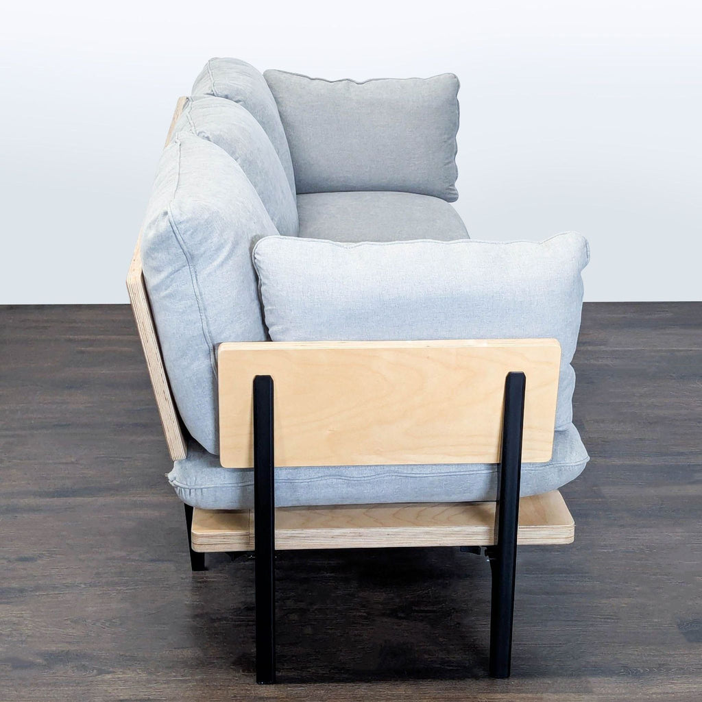 Contemporary 3-seat sofa by Floyd Home with soft gray cushions and sturdy black legs, ideal for living rooms.