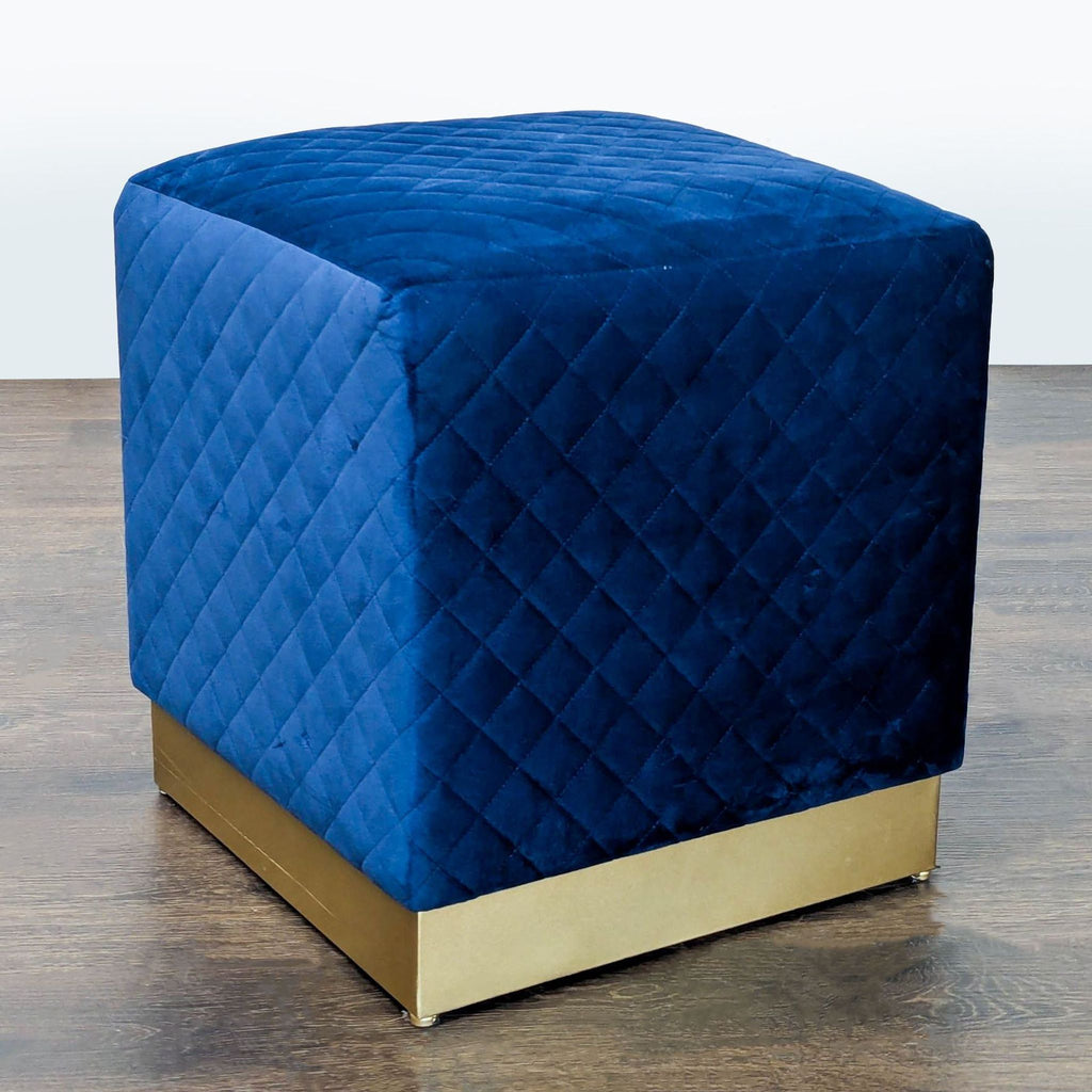 Modern blue velvet ottoman featuring sleek quilting and a gold foundation by New Pacific Direct.