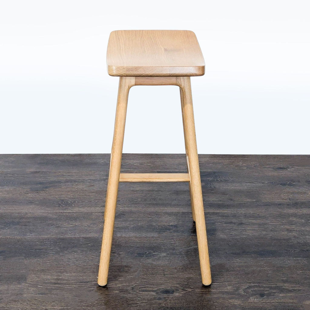 Scandinavian-style wooden stool by Article, showcasing a smooth, ergonomic seat and versatile, elegant look.