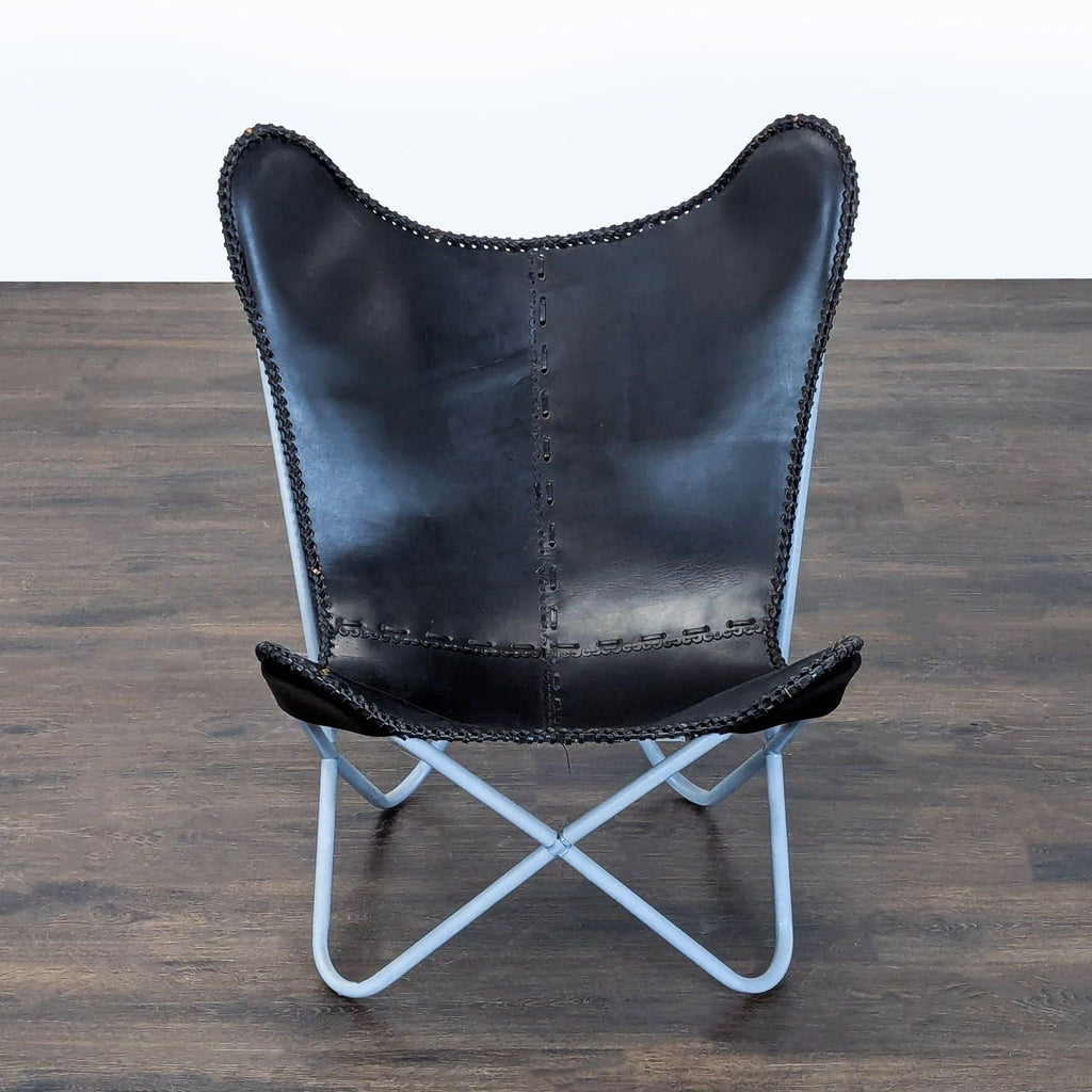 Contemporary lounge chair with black-brown stitched leather seat and eye-catching blue metal legs.
