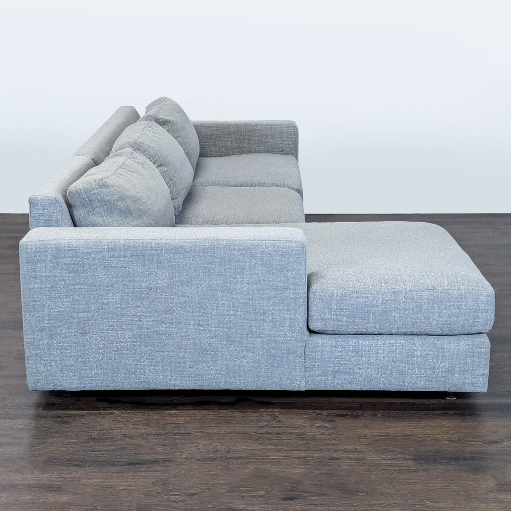 Sleek West Elm sectional in gray fabric with wide arms and a left-facing chaise, perfect for comfortable seating.