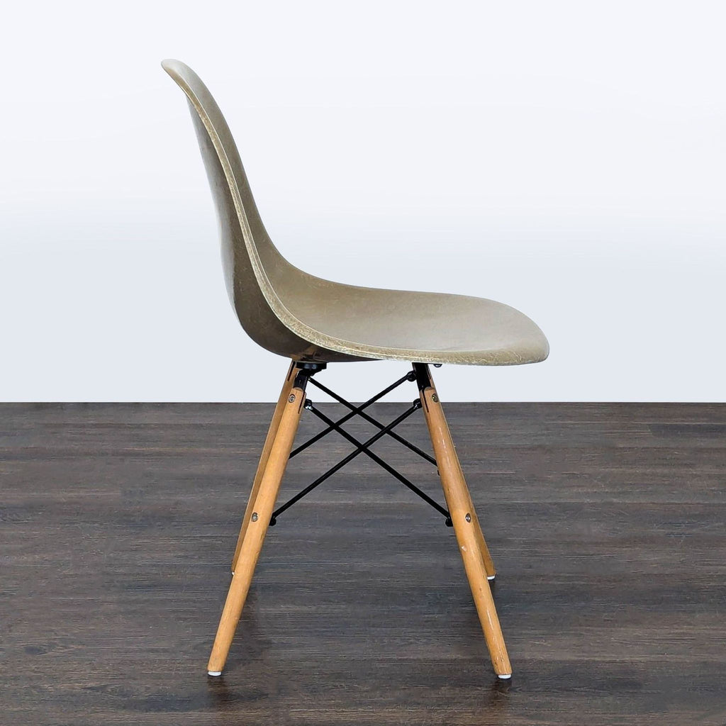 2. Black Modernica dining chair featuring molded seat and tapered wooden legs, displayed in a modern setting.