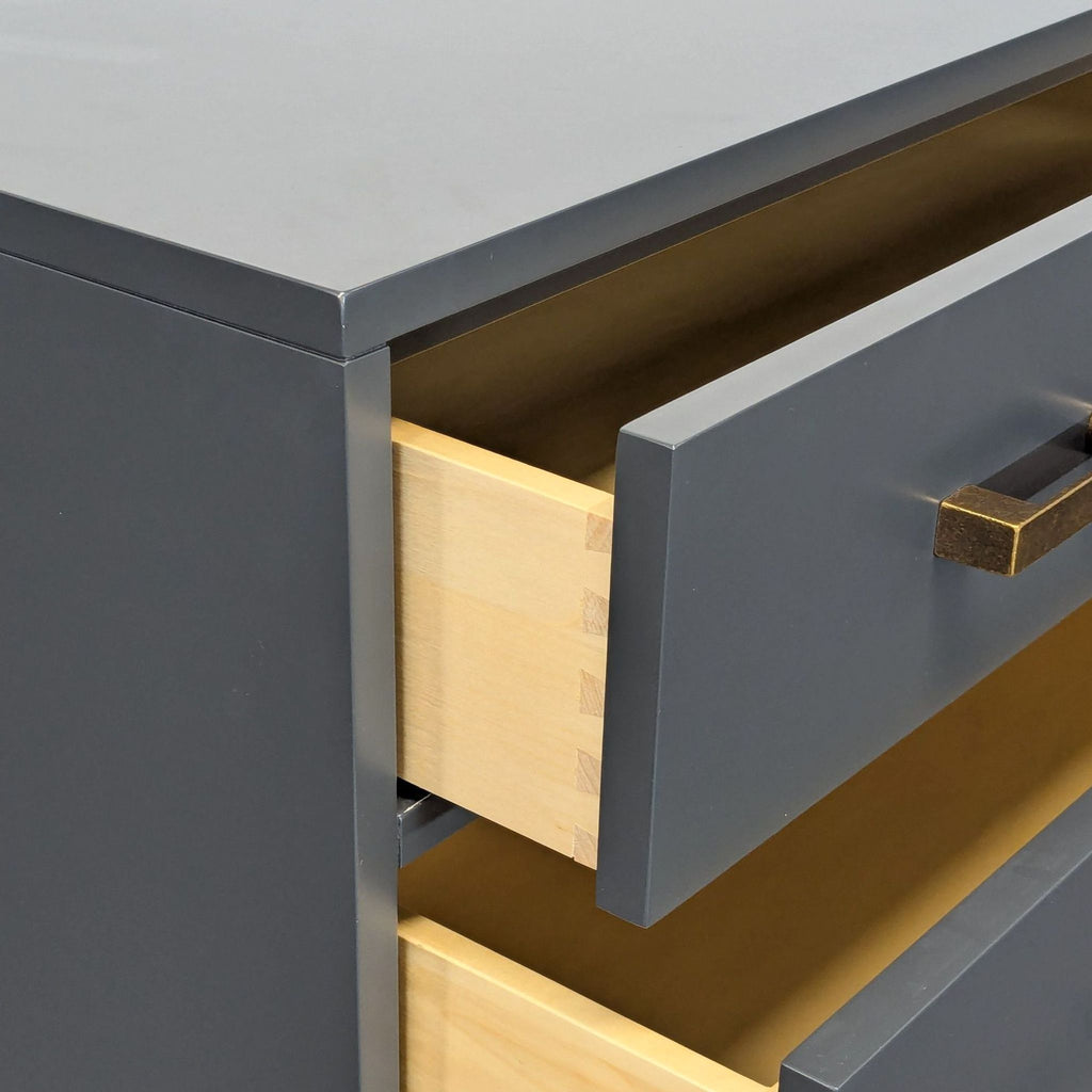 Contemporary four-drawer dresser with natural wood interior and brass handles, perfect for kids' rooms.