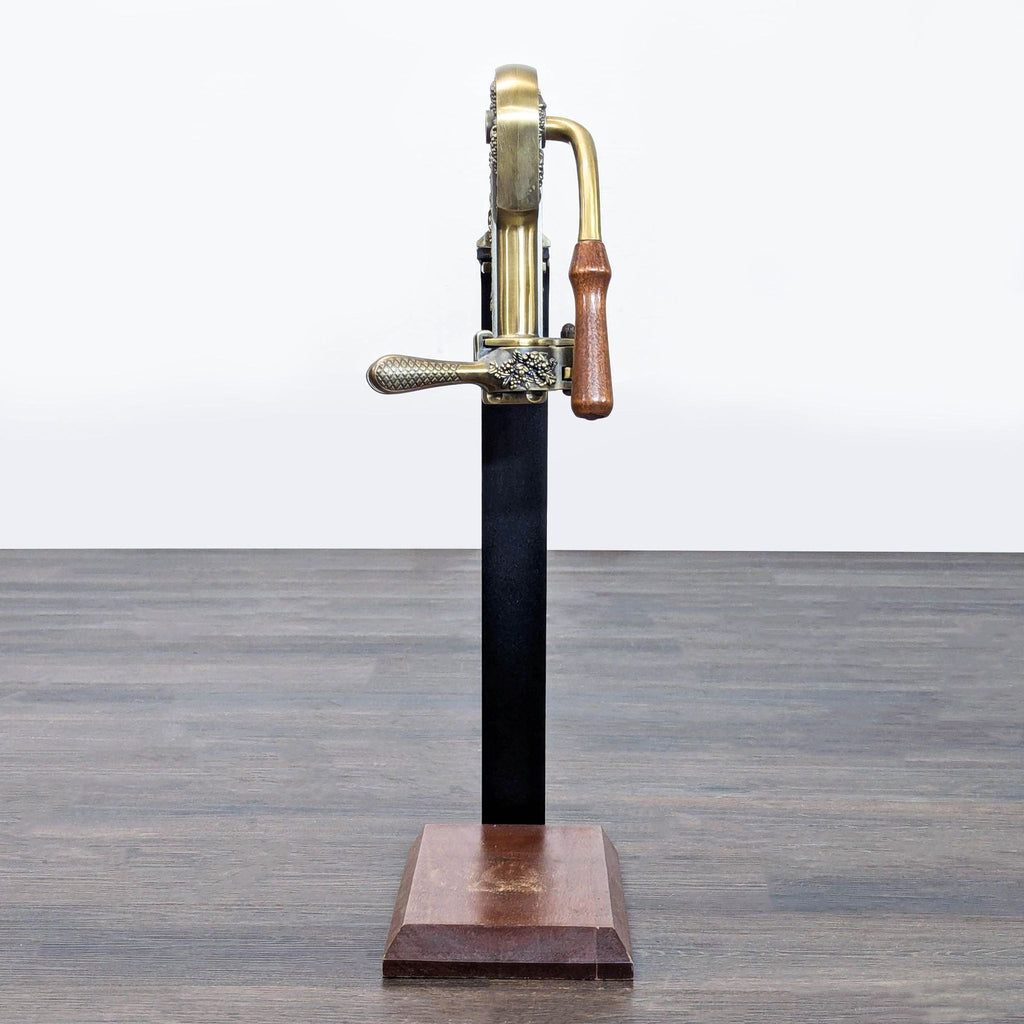 Rogar Estate brass-tone wine opener with floral engravings and turned wood handle, presented on a freestanding stand.